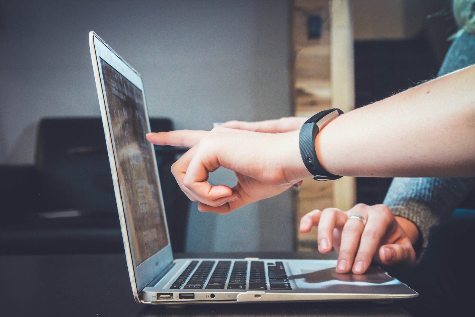 Hands pointing at a laptop during a busy work session when calls pile up