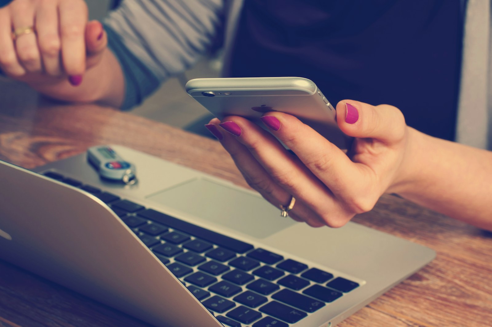 Business owner checking a phone and laptop at their desk